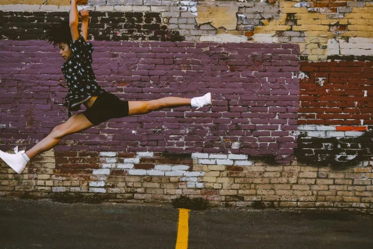 person jumping near brick walls