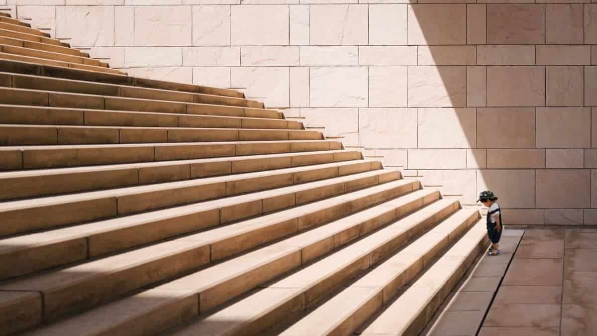 child standing before bottom of stairs